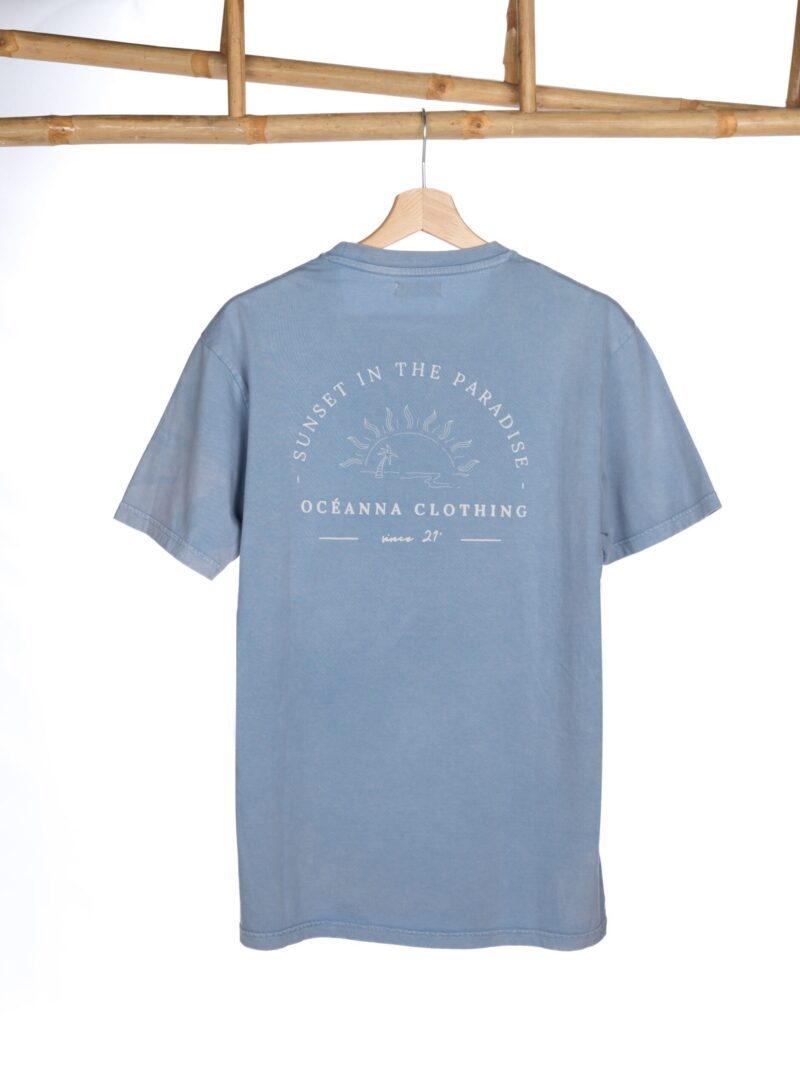 Prenda única y sostenible: camiseta azul de algodón orgánico con diseño "Sunset in the Paradise" de Oceanna Clothing.
