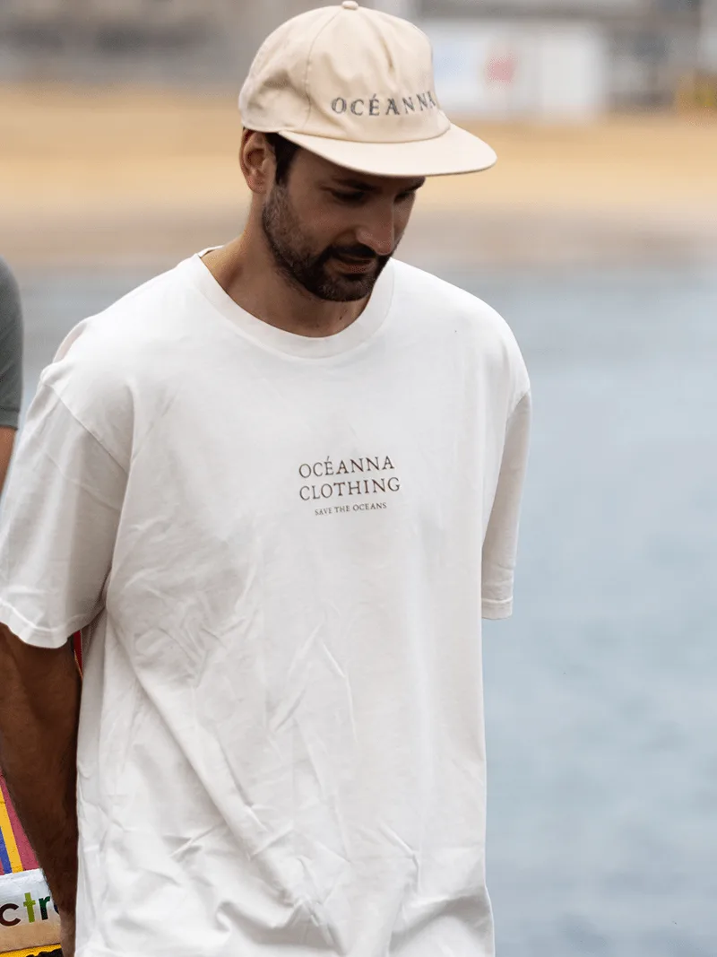 Camiseta unisex "Save the Oceans" de Oceanna Clothing con dibujo de delfín y logotipo de la marca.